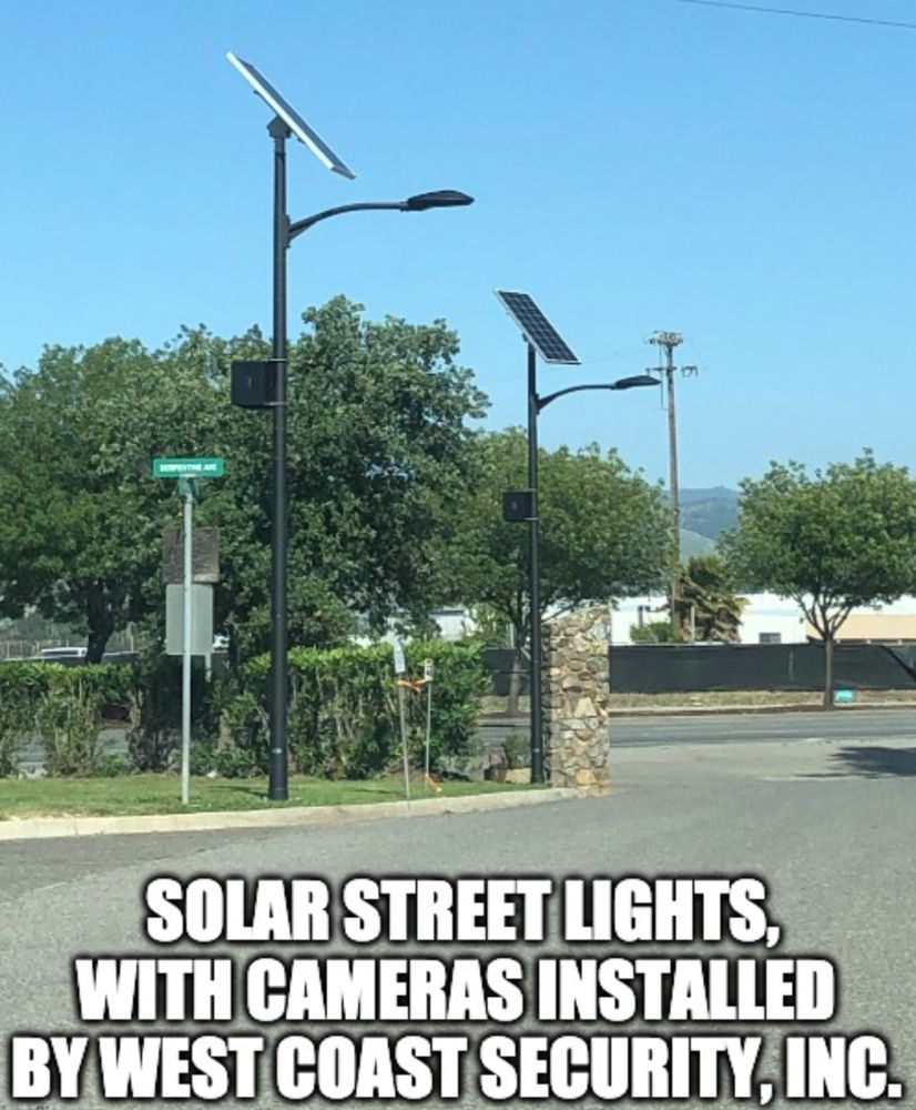 Solar street lights illuminating a roadway at night with surveillance coverage